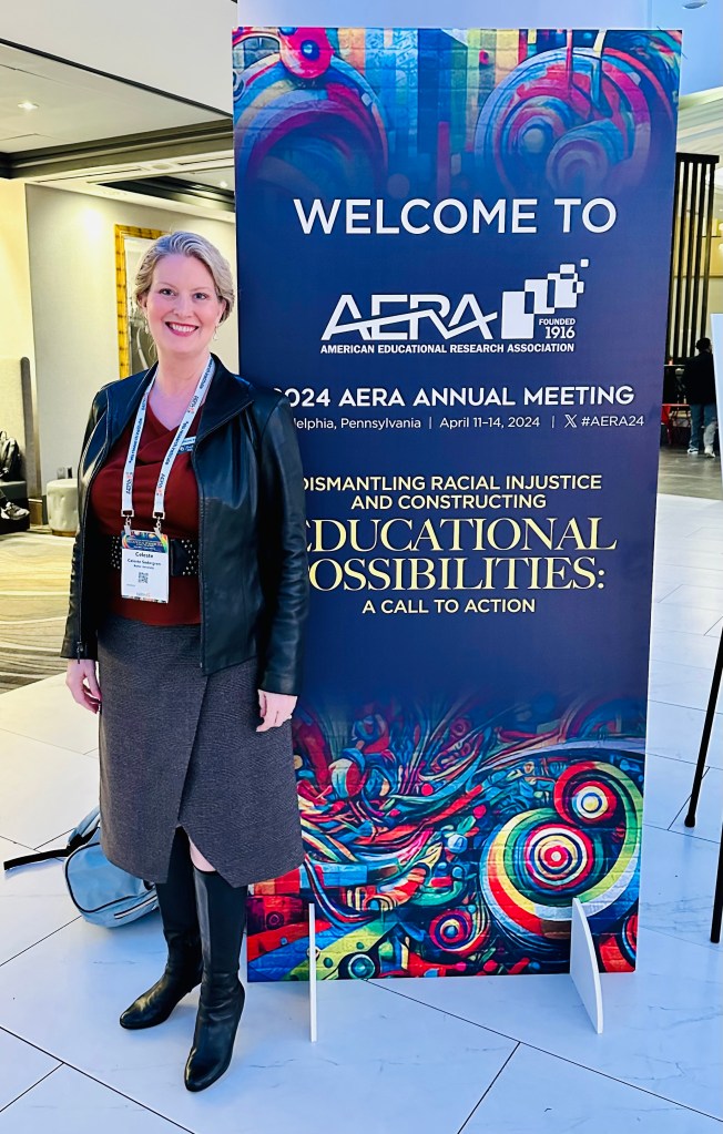 Dr. Sodergren stands in front of the Welcome to AERA conference sign.